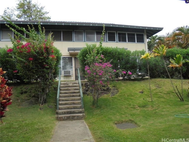 view of front of property featuring cooling unit and a front yard