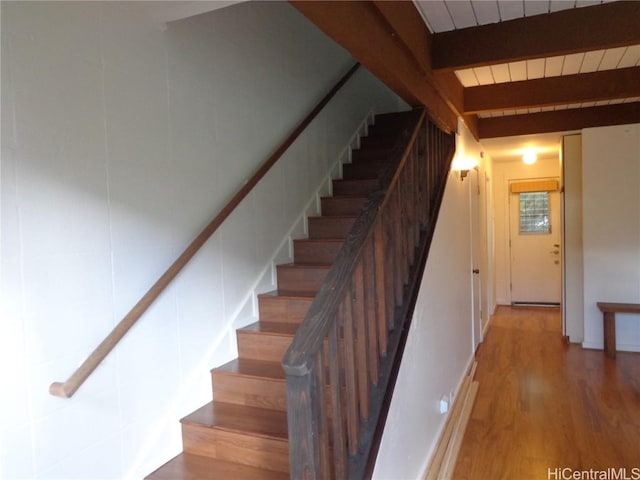 stairs with beamed ceiling, hardwood / wood-style flooring, and wooden ceiling