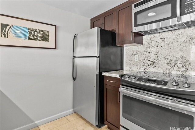 kitchen with tasteful backsplash, stainless steel appliances, dark brown cabinets, and light tile patterned floors