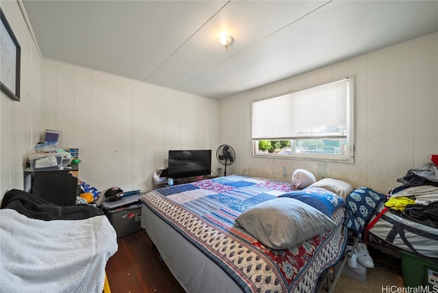 bedroom with wood walls and dark hardwood / wood-style floors