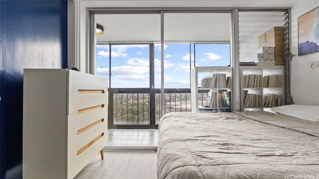 bedroom with light hardwood / wood-style floors and floor to ceiling windows