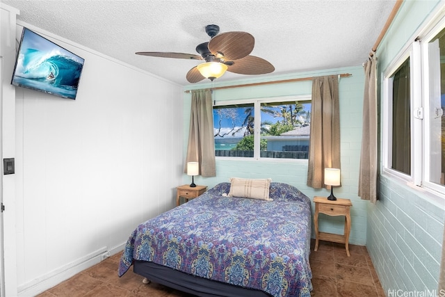 bedroom with tile patterned floors, brick wall, a textured ceiling, and ceiling fan