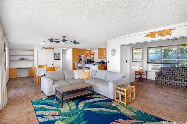 living room with an AC wall unit, a textured ceiling, and ceiling fan