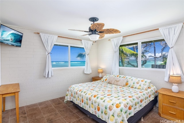 bedroom featuring brick wall, a water view, multiple windows, and ceiling fan