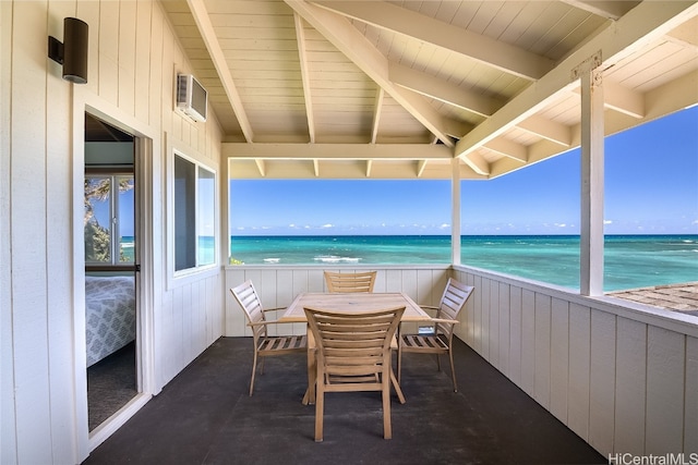 sunroom featuring a water view, beamed ceiling, and a beach view