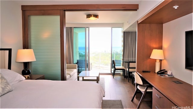 bedroom featuring light hardwood / wood-style floors, access to exterior, and beamed ceiling