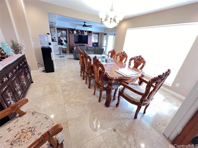 dining area featuring ceiling fan with notable chandelier