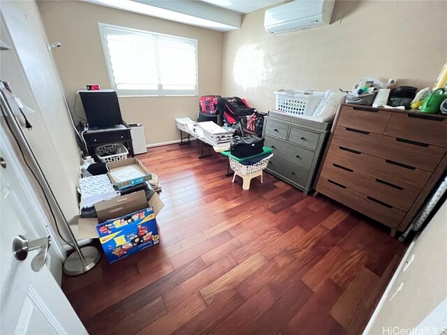 living area with a wall unit AC and dark hardwood / wood-style flooring