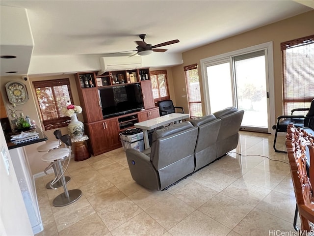 living room with ceiling fan, an AC wall unit, and light tile patterned flooring