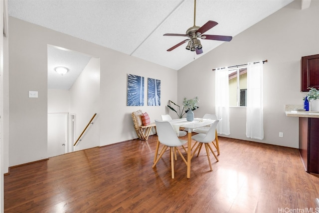 dining room with ceiling fan, lofted ceiling, a barn door, and wood-type flooring