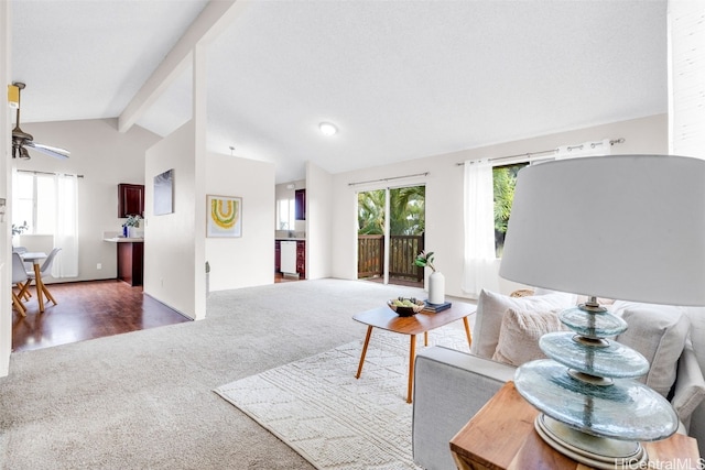 carpeted living room featuring vaulted ceiling with beams and ceiling fan