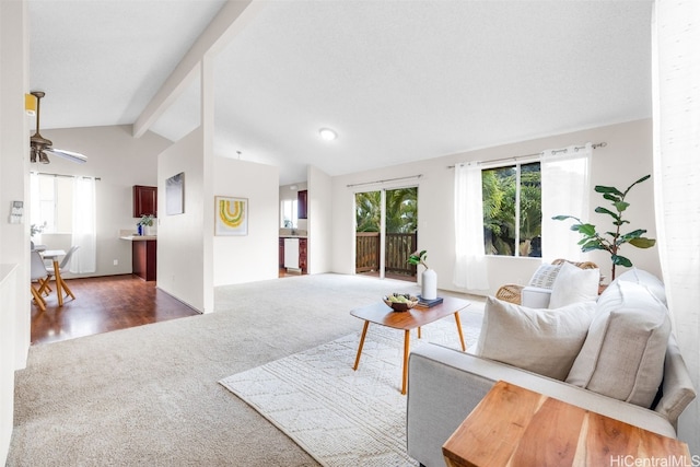 carpeted living room featuring ceiling fan and vaulted ceiling with beams