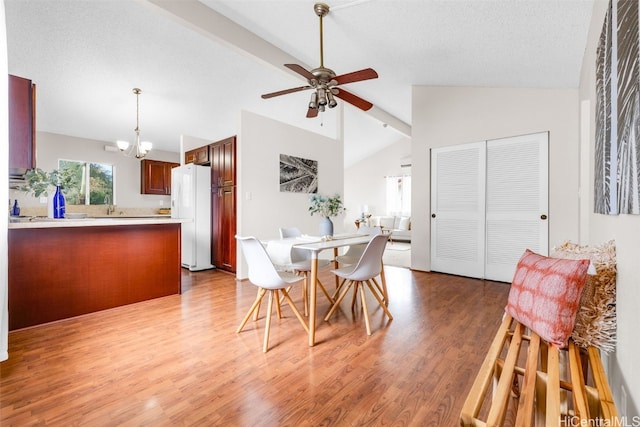 dining room featuring lofted ceiling, sink, hardwood / wood-style flooring, a textured ceiling, and ceiling fan with notable chandelier