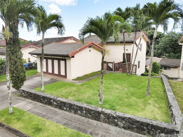 back of house featuring a yard and a garage