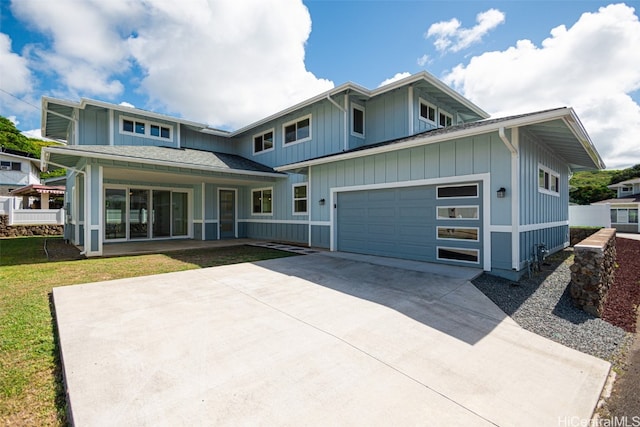 view of front of property with a porch, a front yard, and a garage