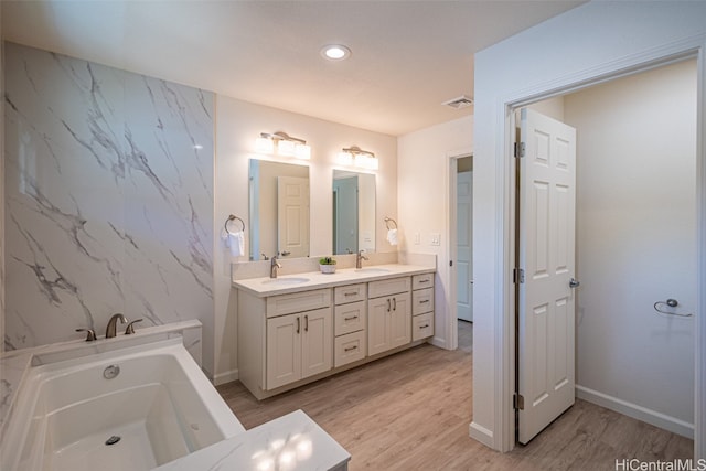 bathroom with vanity, hardwood / wood-style floors, and a bathing tub