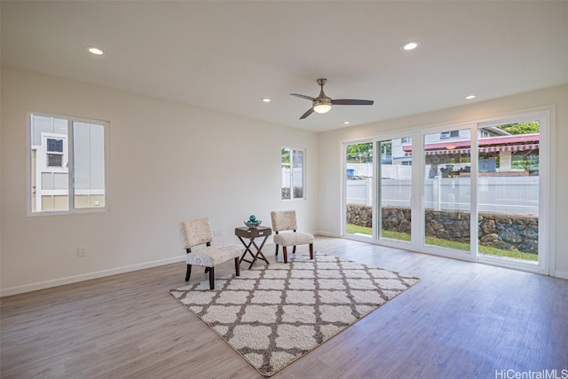 living area featuring light hardwood / wood-style floors and ceiling fan