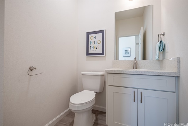 bathroom with vanity, toilet, and wood-type flooring