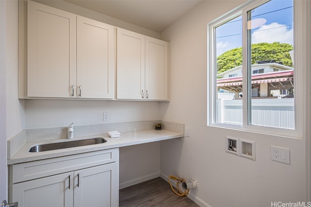 washroom featuring sink, hookup for a washing machine, dark hardwood / wood-style floors, and cabinets