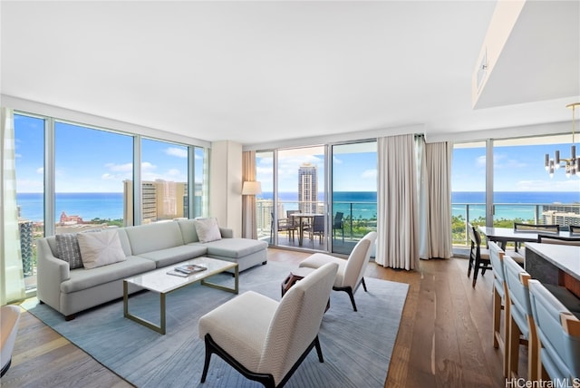 living room with expansive windows, a water view, a healthy amount of sunlight, and hardwood / wood-style flooring