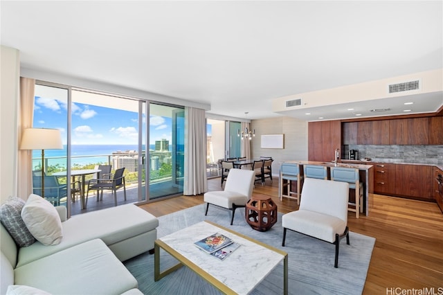 living room featuring a water view, a chandelier, and hardwood / wood-style floors