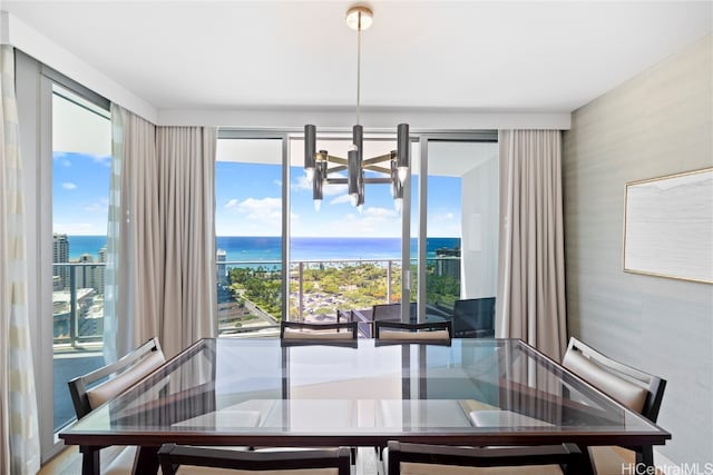 dining area featuring a water view and a notable chandelier