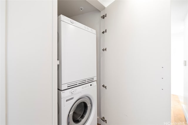 washroom with stacked washer / dryer and hardwood / wood-style flooring