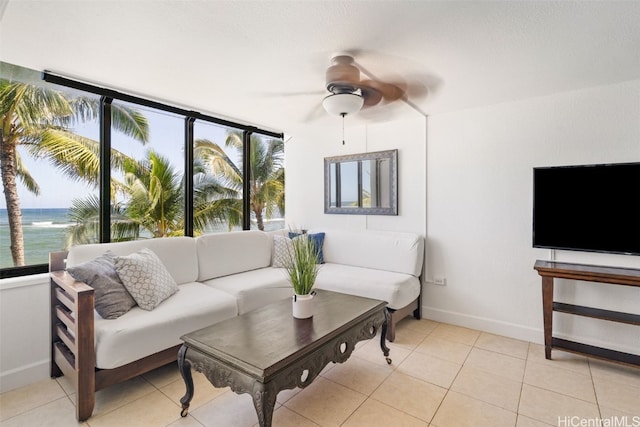 tiled living room with ceiling fan and a water view