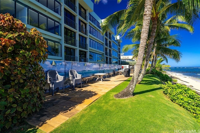 view of yard with a water view and a view of the beach