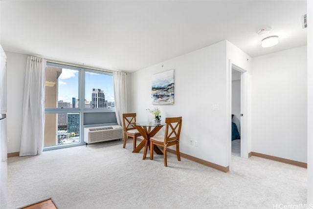 sitting room with a wall unit AC and light colored carpet