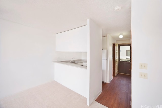 corridor with dark hardwood / wood-style floors, sink, and a textured ceiling