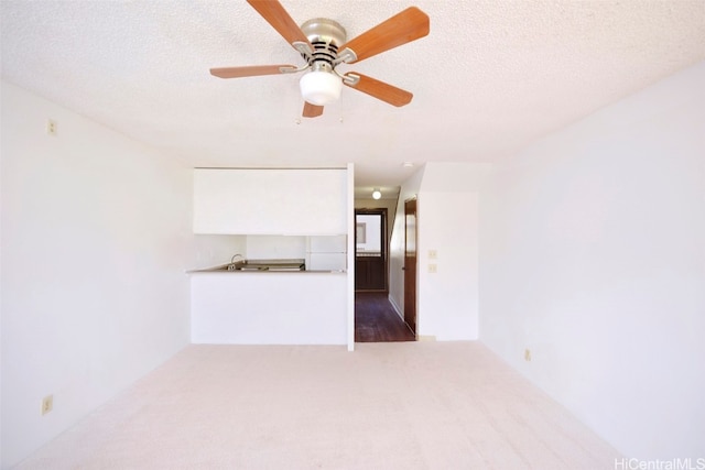 carpeted empty room with a textured ceiling and ceiling fan