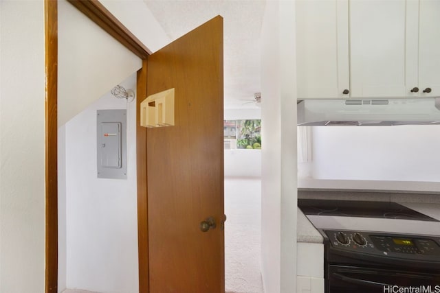 interior details featuring black / electric stove, ceiling fan, carpet, and electric panel