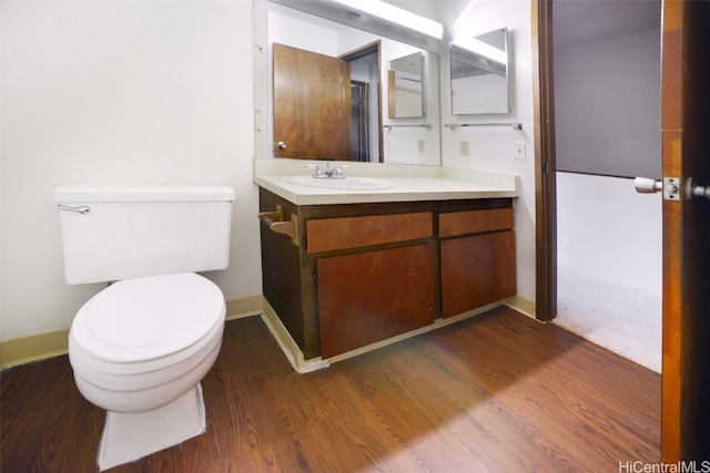 bathroom with vanity, toilet, and hardwood / wood-style floors