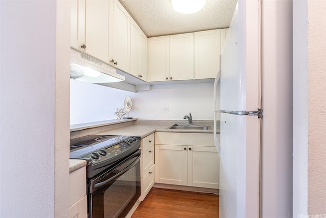 350 Aoloa St Unit A236, Kailua, HI 96734 - kitchen with black / electric stove, freestanding refrigerator, a sink, wood finished floors, and white cabinets