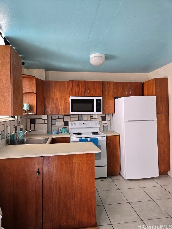 kitchen featuring kitchen peninsula, backsplash, light tile patterned flooring, sink, and white appliances