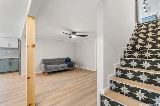 stairway featuring crown molding, hardwood / wood-style floors, and ceiling fan