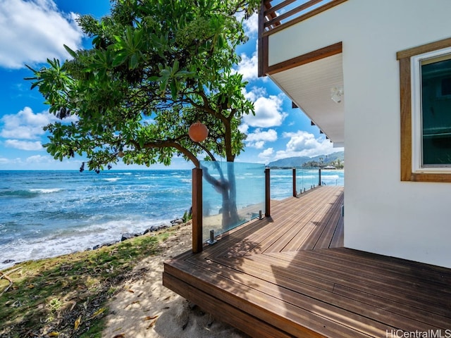 exterior space featuring a dock, a water view, and a view of the beach