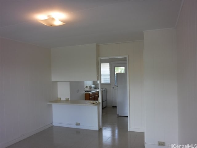 kitchen featuring kitchen peninsula, white refrigerator, and washer / clothes dryer