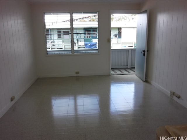 tiled spare room with wood walls