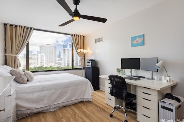 bedroom with light hardwood / wood-style floors and ceiling fan