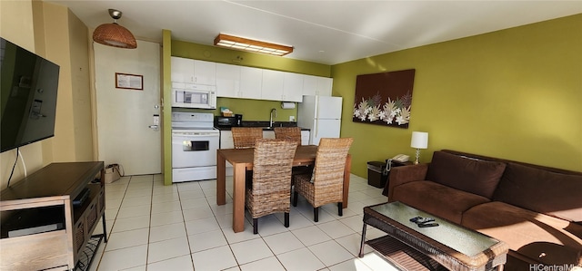 kitchen featuring sink, white cabinetry, white appliances, and light tile patterned floors