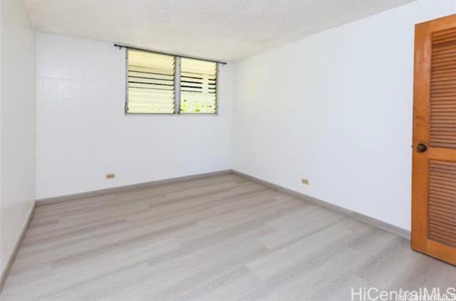 unfurnished room featuring a textured ceiling and light hardwood / wood-style flooring