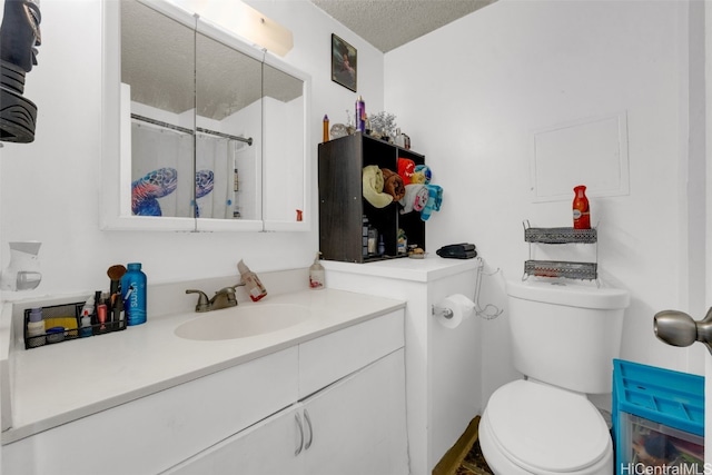 bathroom featuring vanity, a textured ceiling, and toilet