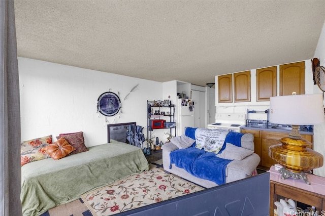 bedroom with white fridge and a textured ceiling