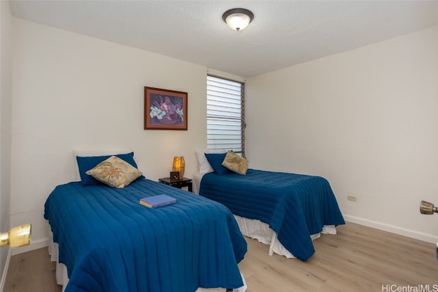 bedroom featuring hardwood / wood-style flooring and a textured ceiling