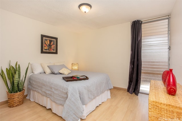 bedroom featuring light hardwood / wood-style floors and a textured ceiling