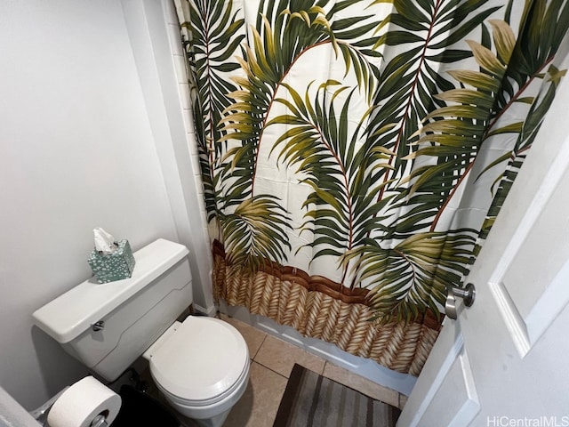 bathroom featuring a shower with shower curtain, toilet, and tile patterned flooring