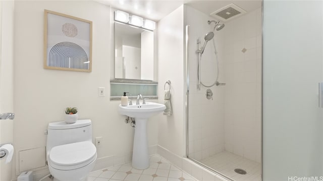 bathroom featuring toilet, sink, and a shower with door