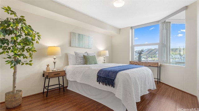 bedroom featuring expansive windows and hardwood / wood-style flooring